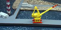 A 1/1250 scale model of a yellow missile loading crane based on that at Bangor submarine base by Coastlines Models CL-LA08.