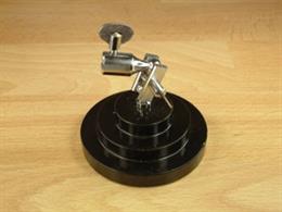 Heavy metal stand for holding self-closing crosslock tweezers, allowing these to be used as clamps for small items and a 'third hand' to hold the workpiece while assembling small components.