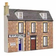 Low relief buildings can be placed along a backscene to give an illusion of depth to a scene.This model features a terraced building adapted into a toy museum.
