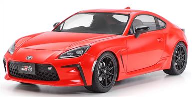 This model assembly kit recreates the 2021 Toyota GR 86 as a 1/24 Sports Car Series product. While the lightweight front- engine and wide body with low center of gravity are carried over from the first generation 86 (2012), the Toyota GR 86 is powered by a bigger 2.4-liter horizontally opposed four-cylinder DOHC engine capable of 235hp for powerful performance. The aluminum engine hood, roof and front fenders are lightweight and rigid. This car also employs air outlets, side sill spoilers, and other parts to bring improved aerodynamic efficiency and steering responsiveness.