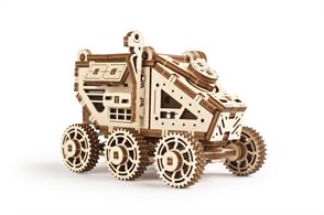 Go far and beyond with the futuristic mini-model of a space conqueror Mars Buggy from the Ugears collection of mechanical models.Spare 30 minutes or so to enjoy the assembly of an ingenious mechanical space vehicle. Inspired by ever-exciting sci-fi and no less amazing recent developments in the space industry, Ugears engineers pay tribute to the final frontier romantics with a six-wheel mechanical space-rover, the Mars Buggy.The above mentioned six-wheel arrangement of the model is cleverly inter-connected to provide better maneuvering: this astronaut’s little helper can ride around and over small obstacles to deliver important samples to the base. The roof of the Mars Buggy opens to accommodate small cargo. If you want to use it in your office space, the Buggy can keep and deliver small stationery items such as paperclips, erasers, sharpeners, etc. On the right side of the rover’s cabin, you will find a camera that will keep track of the Martian environment. And solar panels on either sides of the roof won’t let the energy of your Mars Buggy run dry. All the elements of the model, including camera, solar panels and a ladder in the rear end are made of high-quality plywood. On its front side, the rover proudly carries an image of Mars, the distant planet it is designed to roam.Your new space vehicle comes in a box of 100 × 275 × 9 mm dimensions. All 95 details are pre-cut in ply-wood boards with high-precision lasers and need no glue or additional tools to put together. Completely assembled, it measures 90 × 62 × 68 mm.NASA plans to launch humanity’s first expedition to Mars in 2050. Enterprising and ambitious Elon Musk wants to start his own Mars space mission in 2025. The time is right to get ready to conquer the red planet with Ugears’ Mars Buggy!