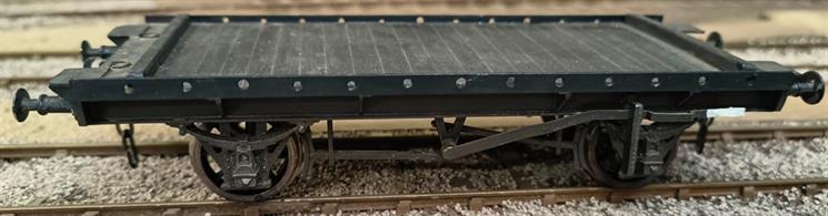 Scratch built from plasticard sheet and strip with cast whitemetal W irons, axleboxes, brake fittings and buffers.Detailing includes tie-down rings, buffer wheel bridges and wheel stop baulks for a GWR lever-braked Serpent/Cartruck.Nicely built, finished in GWR goods grey, no lettering.
